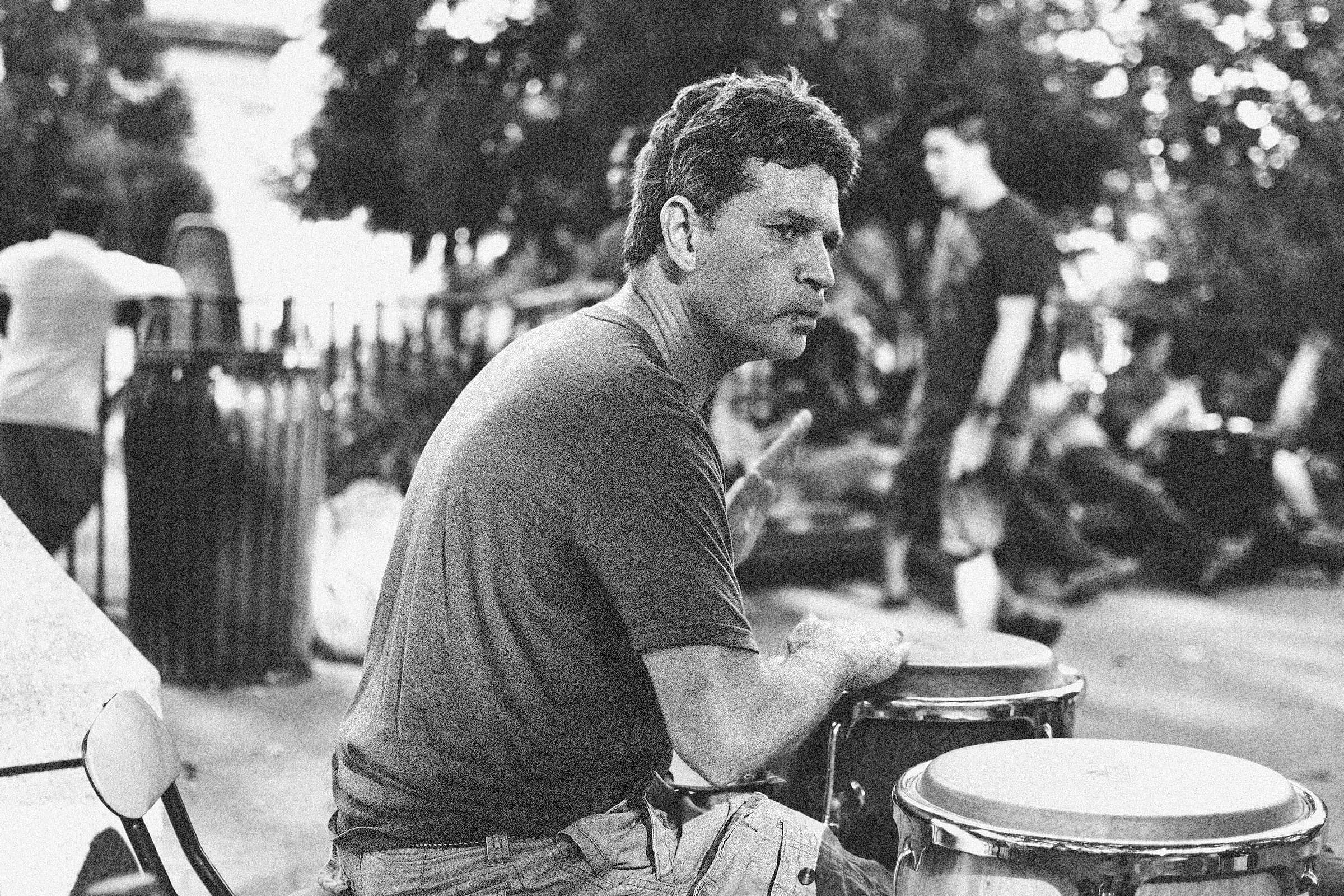 Black and white portrait of a man playing bongos in Union Square Park