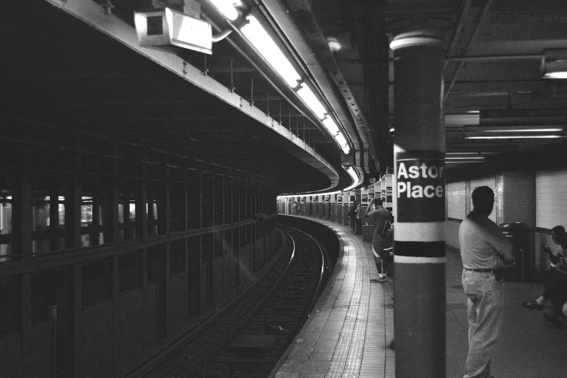 Photo of the Astor Place subway station, with people waiting for the train
