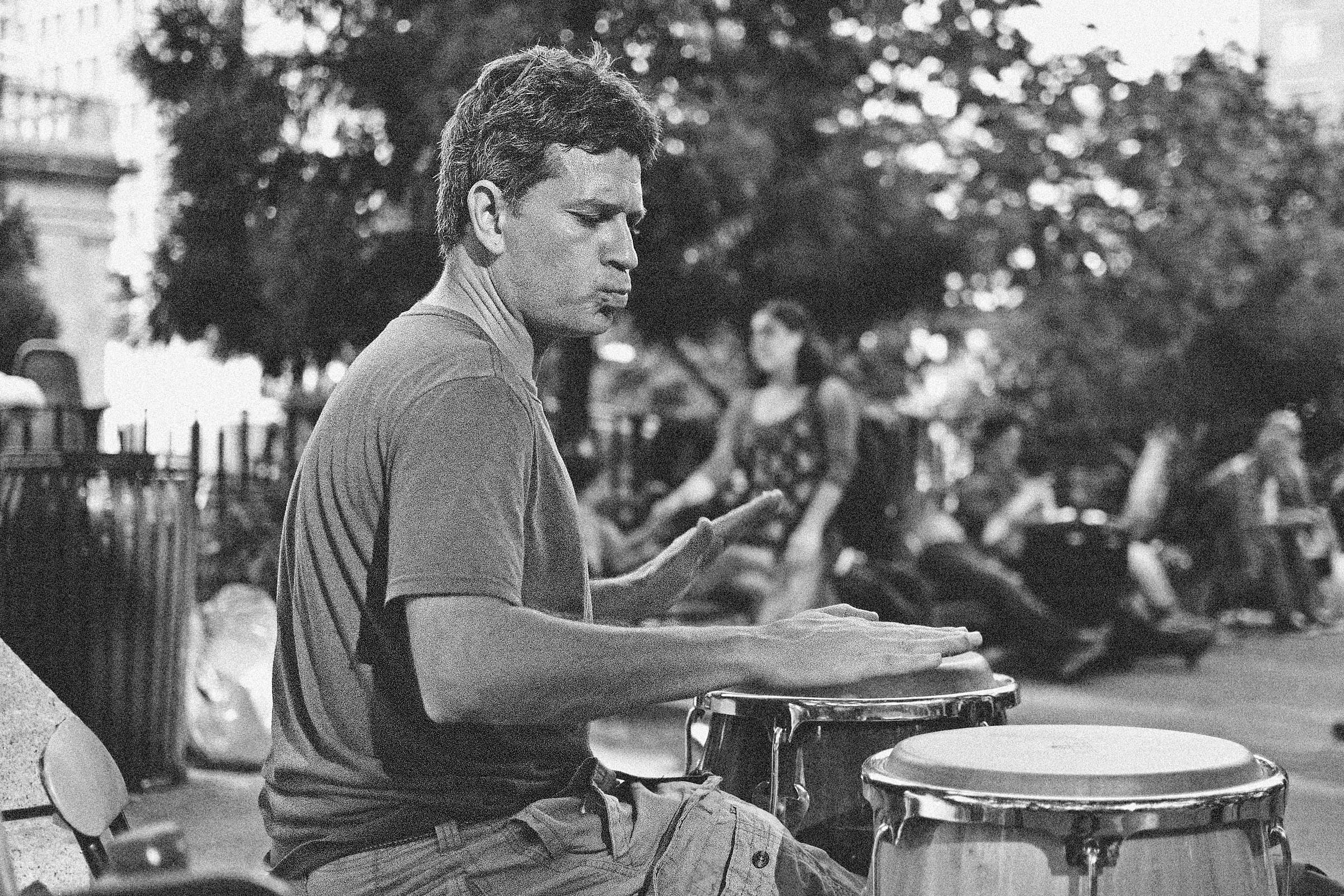 Black and white portrait of a man playing bongos in Union Square Park