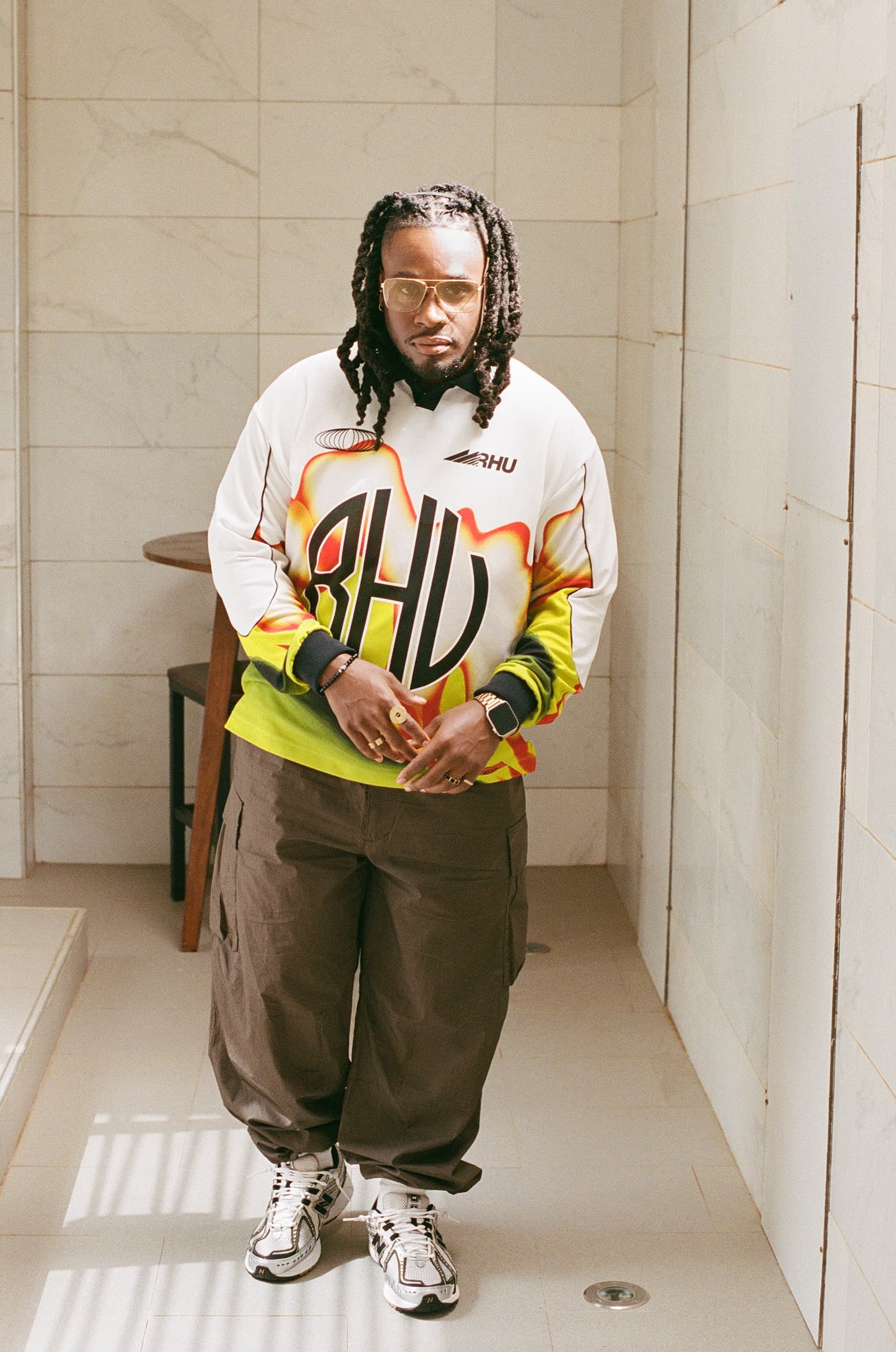 Portrait of a man in an athletic jersey, standing indoors in a hallway